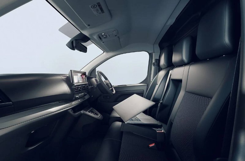 Front interior view of a van with seats and a dashboard.
