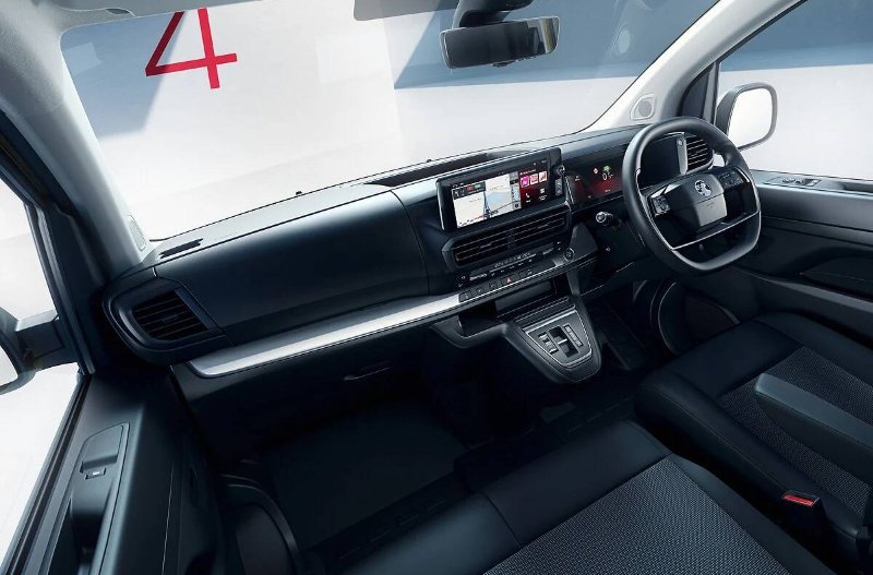 Interior view of a car showing the dashboard, steering wheel, and display screen.