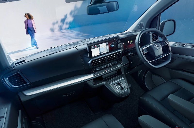 Inside view of a modern car dashboard with digital displays and steering wheel.