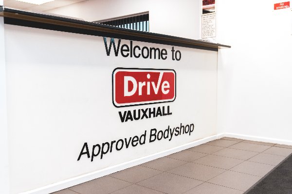 Reception area with Welcome to Drive Vauxhall Approved Bodyshop sign.